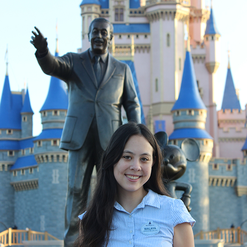 Malaya Heflin poses in front of Disneyworld in Orlando, FL